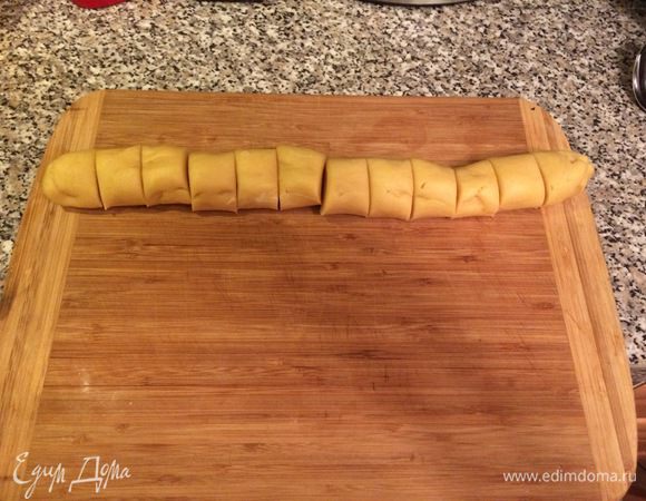 Через полчаса достаем из холодильника тесто, раскатаем из него колбаску и разрежем его на 12 равных частей.