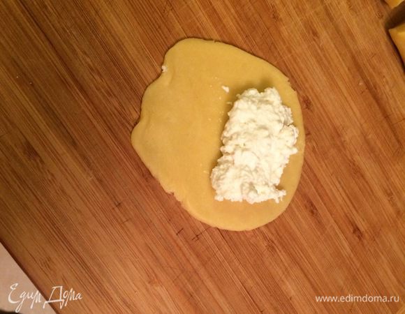Каждую часть раскатаем в лепешку средней толщины. В середину лепешки выкладываем творог и сформируем сочник. Края я заклеиваю. Творога я кладу много, так как люблю больше начинки, но можно и поменьше, тогда нужно будет 250 г творога.