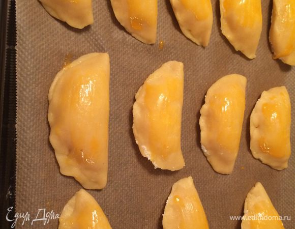 Сочники укладываем на противень, застеленный пергаментной бумагой. Желток взбить вилкой и смазать кондитерской кистью поверхность каждого сочника. Выпекать при температуре 190°С 20 — 25 минут.