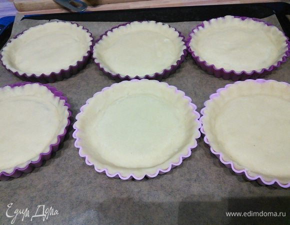 Тесто разделить на 6 равных частей, раскатать и выложить им формочки-тарталетки. Можно выпекать большим тартом. Заготовки отправить в холодильник до востребования. 