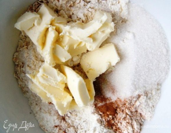 Для крамбла смешать хлопья, муку, сахар, корицу и сливочное масло из холодильника. Руками перетереть в крошку. 