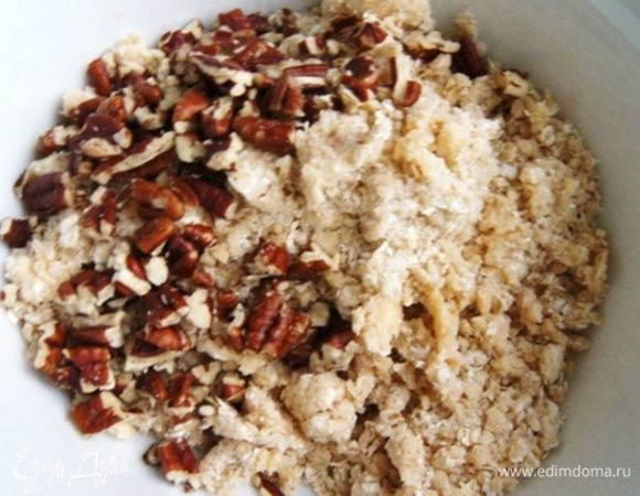 Орехи порубить ножом и добавить к крошке.