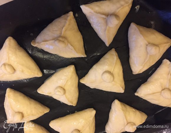 Противень застелить пекарской бумагой, раскладываем на ней наши пирожки. Смазывем взбитым яйцом. Даем постоять минут 20. 
Духовку разогреть до 180°С. Выпекать минут 10 — 15. 