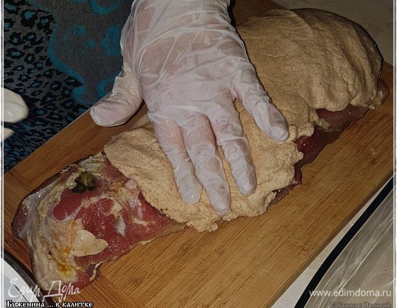 И обмазываем мясо тестом. Заключаем, значит, его, мясо, в калитку. Сначала с одной стороны.