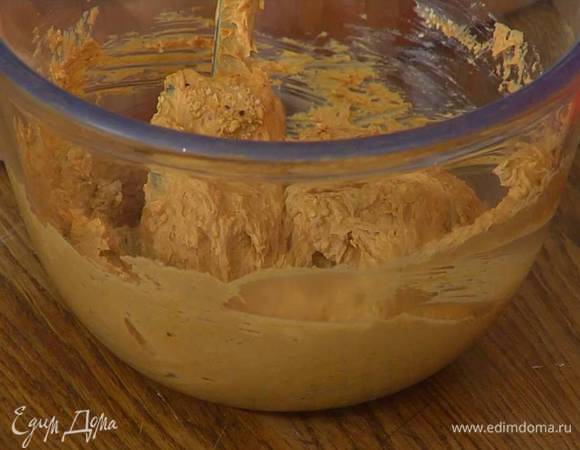 Приготовить крем: сгущенное молоко соединить с предварительно размягченным сливочным маслом и взбить блендером с насадкой-венчиком на маленькой скорости в однородную, гладкую массу, затем добавить большую часть измельченных орехов и все перемешать.