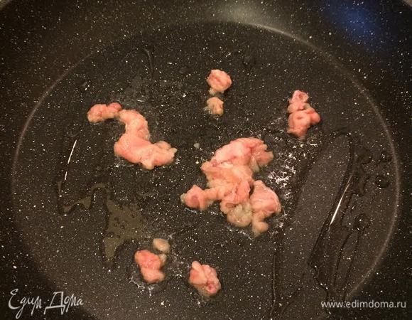 Разогреть сковороду с толстым дном, добавить немного растительного масла и мелко нарезанный жир, тушить 2 — 3 минуты.
