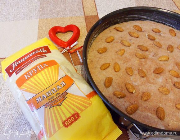 Форму для выпечки смазать маслом. выложить в нее тесто, посыпать оставшимися миндалем и сахаром. Духовку разогреть до 180°С. 