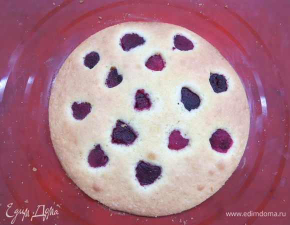 Готовим корж. Взбить размягченное масло и сахар добела. Добавить яйцо, взбить и всыпать муку. Еще раз перемешать на низких оборотах. Положить пергамент на противень и намазать тесто на нарисованный круг. Равномерно распределить по кругу ягоды малины, немного вдавливая в тесто. Выпекать около 10 минут при температуре 200°С в заранее разогретой духовке. Вынуть и остудить. Положить заготовку в разъемную форму и собрать ее. Если нужно, обрежьте края коржа.