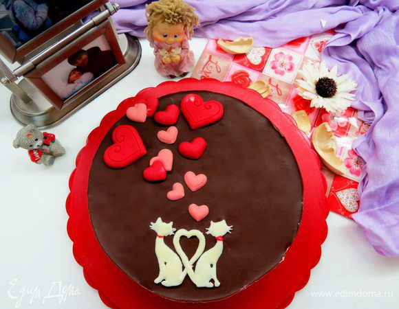 Для глазури нужно растопить шоколад (я брала горький, 78% какао) и 50 г сливочного масла. Я обычно делаю это в микроволновке. Перемешать, должна получиться жидкая глазурь и вылить ее на суфле, вращая форму, чтобы глазурь распределилась равномерно. Все, торт «Птичье молоко» желательно подержать полчасика в холодильнике и можно подавать! Украсить можно по желанию. У меня в честь праздника парочка влюбленных котов и сердечки из шоколада. Сердечки сделаны с помощью молда из окрашенного в красный цвет шоколада, а котиков обвела растопленным шоколадом по трафарету, после застывания шоколада переложила фигурку на торт.