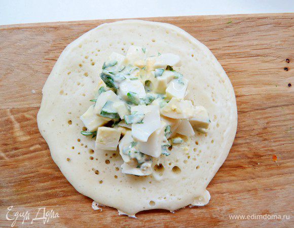 Выпекаем блины на сковороде только с одной стороны. Выливаем небольшой половник с тестом в середину сковороды, тесто само чуть-чуть растекается и получается блин. Признак готовности блина — это полностью подсохший (без влажных пятен) верхний слой. На центр незажаренной стороны блина положите начинку. 