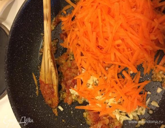 Лук, чеснок потушить на растительном масле. Добавить томатную пасту, перемешать. Добавить морковь, перемешать и тушить под крышкой 5 минут.