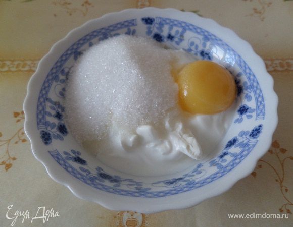 В чашку выкладываем сметану, сахар и яичный желток. Перемешиваем.