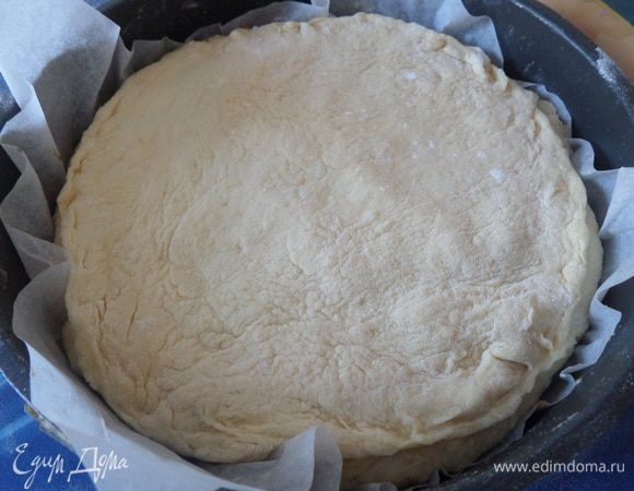 Меньшую часть теста раскатываем в лепешку. Накрываем начинку. Защипываем края.
