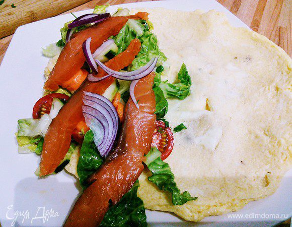 Выкладываем омлет на тарелку, на одну сторону выкладываем салат и кусочки лосося (рыбка тоже может быть любая).