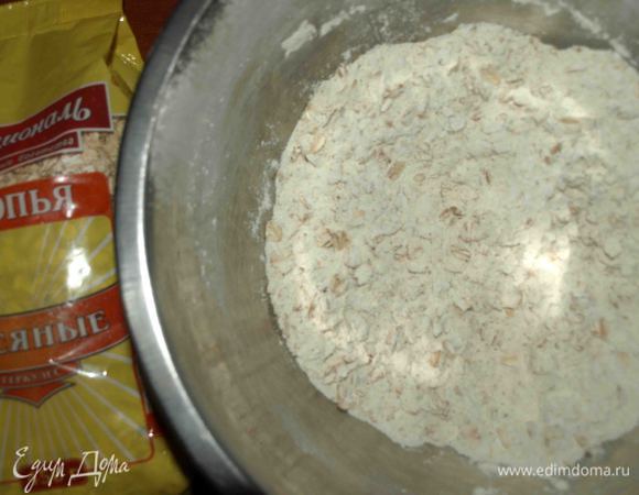 Муку просеять и соединить с овсяными хлопьями Геркулес ТМ «Националь». Добавить соль, разрыхлитель или соду, измельченные каштаны (50 г), сахарную пудру. Перемешать.

