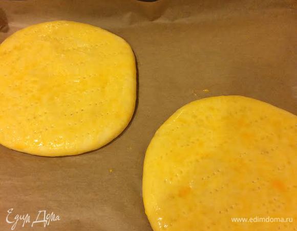 Лепешки смазать яйцом и наколоть вилкой.
