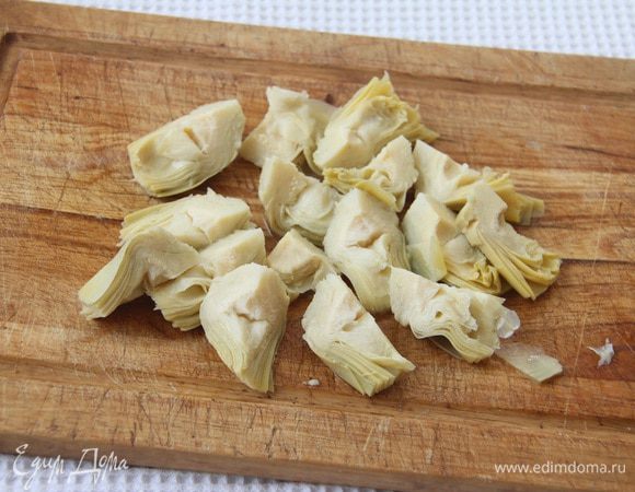 Разрезать маринованные артишоки  (3 — 4 шт.) на четвертинки.