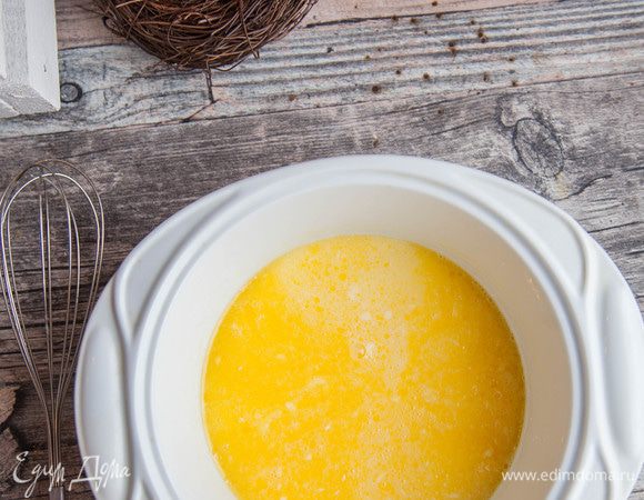 Масло растопить в СВЧ, остудить, добавить в яичную смесь, влить теплое молоко  «Домик в деревне», продолжать взбивать.
