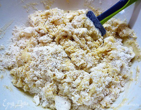 Добавляем в мучную смесь взбитые с сахаром яйца и вымешиваем тесто руками до однородной консистенции.