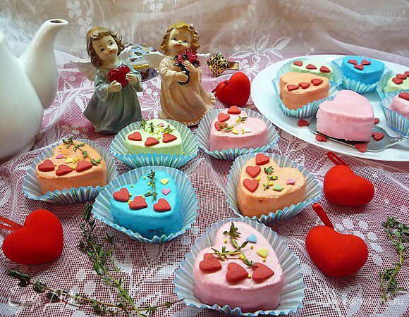 Украшаем пирожные карамельными сердечками, бусинками, листиками свежего тимьяна и укладываем в бумажные корзиночки.