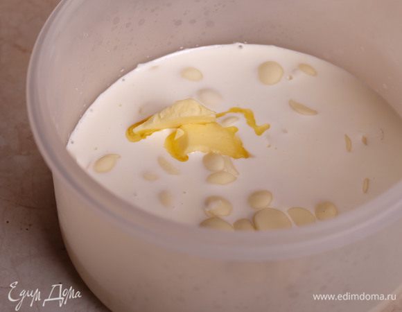 Приготовим ганаш из белого шоколада. Немного растапливаем шоколад в микроволновке (короткими импульсами по 10 секунд), одновременно доводим сливки до кипения. Заливаем шоколад сливками, добавляем сливочное масло.