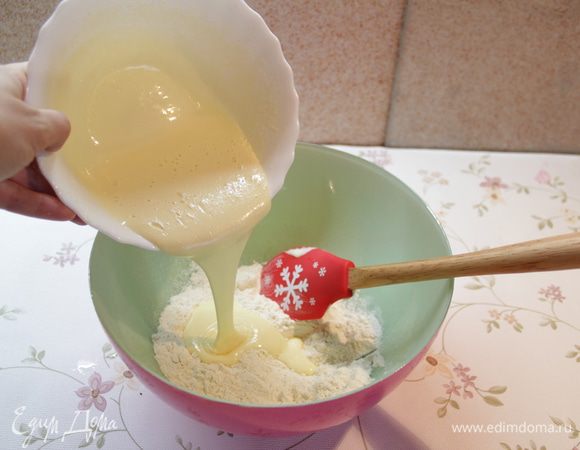 Смешать муку с содой, влить туда яично-сахарную смесь и тщательно перемешать.