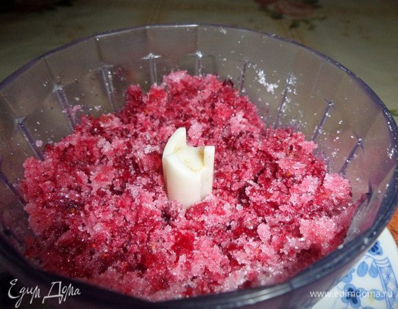 Клюкву кладем в чашу блендера. Добавляем оставшийся сахар. Измельчаем. 
