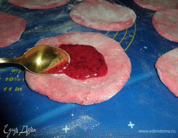 На рабочей поверхности раскатываем небольшие лепешки из теста. Смазываем клюквенной смесью.
