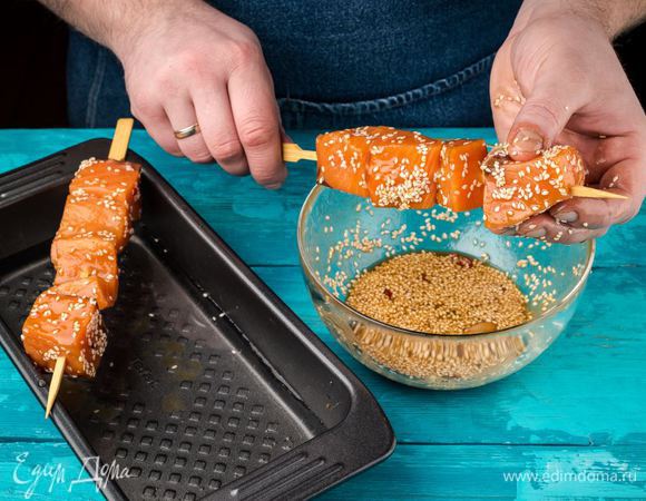 Нанизываем рыбу на шпажки. В форму для запекания наливаем немного воды, раскладываем шпажки с рыбой так, чтобы они держались на краях формы и были на весу. Духовку разогреваем до 200°С. Запекаем шашлычки 15 минут.