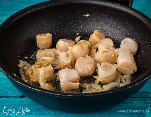 Добавляем гребешки к луку и чесноку. Добавляем по вкусу специи и готовим до золотистого цвета.