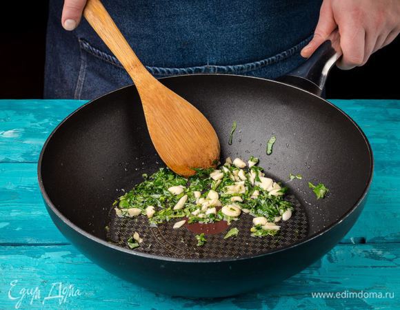 Измельчите чеснок и нарежьте базилик. В сковороде нагрейте оливковое масло, добавьте чеснок и базилик. Обжарьте до золотистого цвета чеснока.