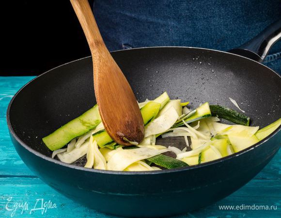 Цукини режем тонкими пластинами, лук — тонкой соломкой и обжариваем на оливковом масле на отдельной сковороде.