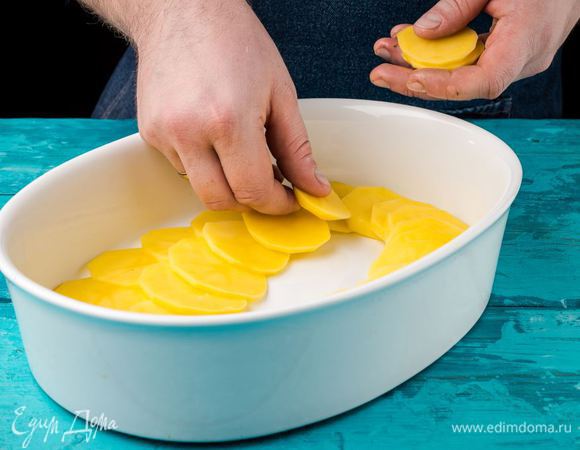 Картофель нарезать кружочками. Форму для запекания смазать оливковым маслом, выложить слой картофеля.