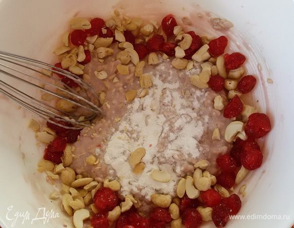 Добавляем в тесто орехи и вишню, тщательно перемешиваем. После чего противень застилаем бумагой для выпечки.