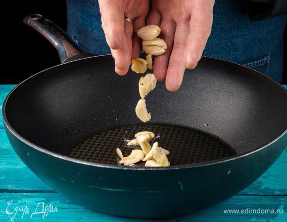 Разогреть оливковое масло на сковороде. Добавить чеснок, раздавленный плоской стороной ножа. Слегка поджарить до появления аромата. 