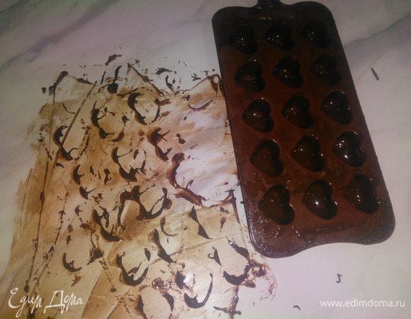 Шоколад растопить. Для этого есть два варианта: 1) на водяной бане, 2) в микроволновке 1 минута на полной мощности.
Формочка для конфет должна быть специальной, на ней должно быть указано «для приготовления шоколадных конфет».
Формочка для льда не подойдет, конфеты плохо выходят из таких форм и ломаются.
С помощью маленькой ложечки покрыть формочки шоколадом. Необходимо добиться равномерного покрытия стенок. Удобно надавливать снизу на дно каждой формочки и таким образом распределять шоколад по стенкам.
Побить формочку об стол сначала дном, потом перевернуть и побить верх дном, чтобы вытек весь лишний шоколад. Сразу, пока шоколад не застыл. собрать его со стола лопаткой, он нам еще пригодится.