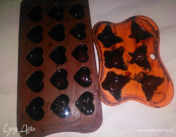Отправить формочку с шоколадом на 5 минут в холодильник застывать.
После остывания еще раз просмотреть каждую формочку, чтобы не было пустот, особое внимание уделить тому участку стенок, который будет соединяться с дном.
В каждую формочку положить по вишенке и залить сиропом. Важно не заполнять сиропом до верха, оставить примерно 1 мм для шоколадной крышки.
Убрать в холодильник на несколько часов, можно даже на ночь, чтобы начинка сверху схватилась и подсохла.