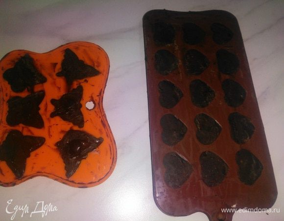 Включить конфорку на плите, чистый нож накалить слегка. Теплым ножом аккуратно снимать излишки шоколада. Одного нагрева хватает на 2 конфетки. Затем нож протереть салфеткой и повторить процесс. После выравнивания еще немного охладить конфеты и вынуть из формочки, аккуратно надавливая на дно.
