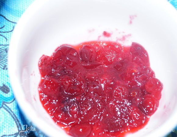 Слегка разминаем клюкву ложкой, чтобы ягодки лопнули. 