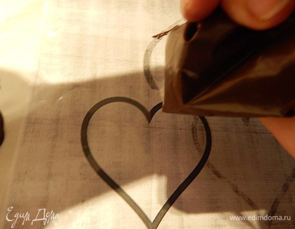 Шоколад растопить одним из трех способов: 1) в микроволновке 1 минуту на полной мощности, 2) в миске на паровой бане, 3) шоколад поломать на кусочки, положить в пакет или кулинарный мешок и опустить его в глубокий стакан, наполненный водой, температура, которой 50°С. Следить за тем, чтобы вода не попала в пакет с шоколадом, периодически доставать пакет из воды и разминать шоколад, чтобы он растаял равномерно.
Растопленный шоколад переложить в кулинарный мешок или плотный пакет, или сделать кулек из пергамента. Кончик пакета срезать, так чтобы получалось отверстие 2 — 3 мм.