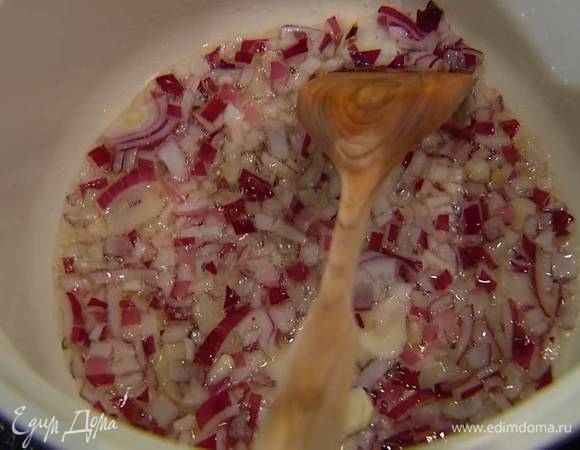 В глубокой кастрюле с тяжелым дном разогреть оливковое масло и обжарить лук и чеснок.