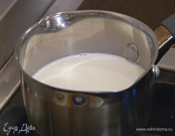 Молоко влить в кастрюлю, добавить 100 мл воды, сахар и нагреть на маленьком огне примерно до 40°С.