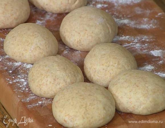 Отдохнувшее тесто выложить на посыпанную мукой рабочую поверхность, разделить на 8 частей, сформировать небольшие шарики, накрыть их сухим полотенцем и оставить для расстойки в теплом месте.