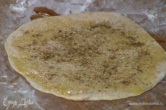 Подошедшее тесто раскатать в очень тонкие лепешки, при помощи кисточки смазать оливковым маслом и посыпать заатаром.