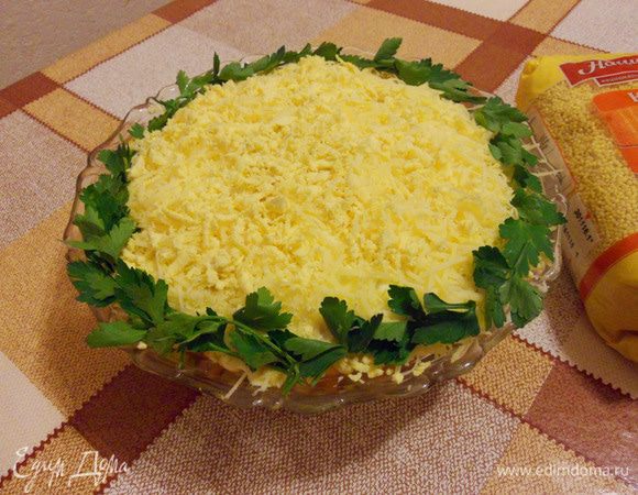 Сверху салат посыпать тертым сыром с раскрошенными желтками и украсить петрушкой.