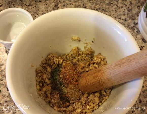 Орехи растолочь в ступке. Затем добавить чеснок (выдавить через пресс), специи, соль и еще раз хорошо размять.
