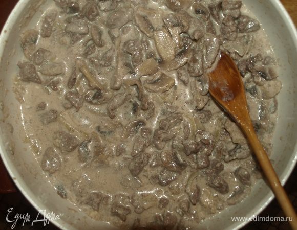 Добавляем фету к мясу с грибами и томим, пока не выпарится половина жидкости. Добавляем муку и томим, пока начинка не загустеет. 