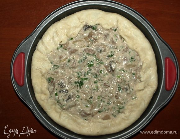 Раскатать тесто, чтобы оно по диаметру было на 2 — 3 см больше формы (на такое количество теста и начинки идеальна форма с диаметром 21 — 23 см). 
Тесто перекладываем в форму. Загибаем вверх края. Выкладываем начинку, разравниваем. Закрываем начинку по краю загнутым тестом. Отправляем в заранее разогретую до 180°С градусов духовку на 30 минут. 
