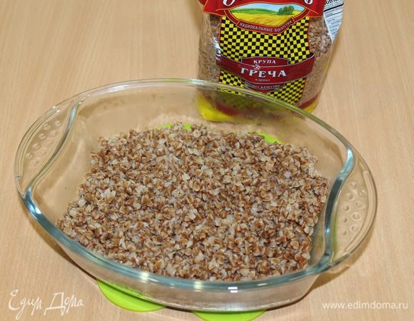 Отварите гречку ТМ «Националь» в курином бульоне. Форму для запекания смажьте маслом и выложите половину гречневой крупы.