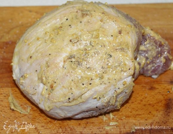 Затем свинину переложить на рабочую поверхность и хорошо смазать горчицей со всех сторон.